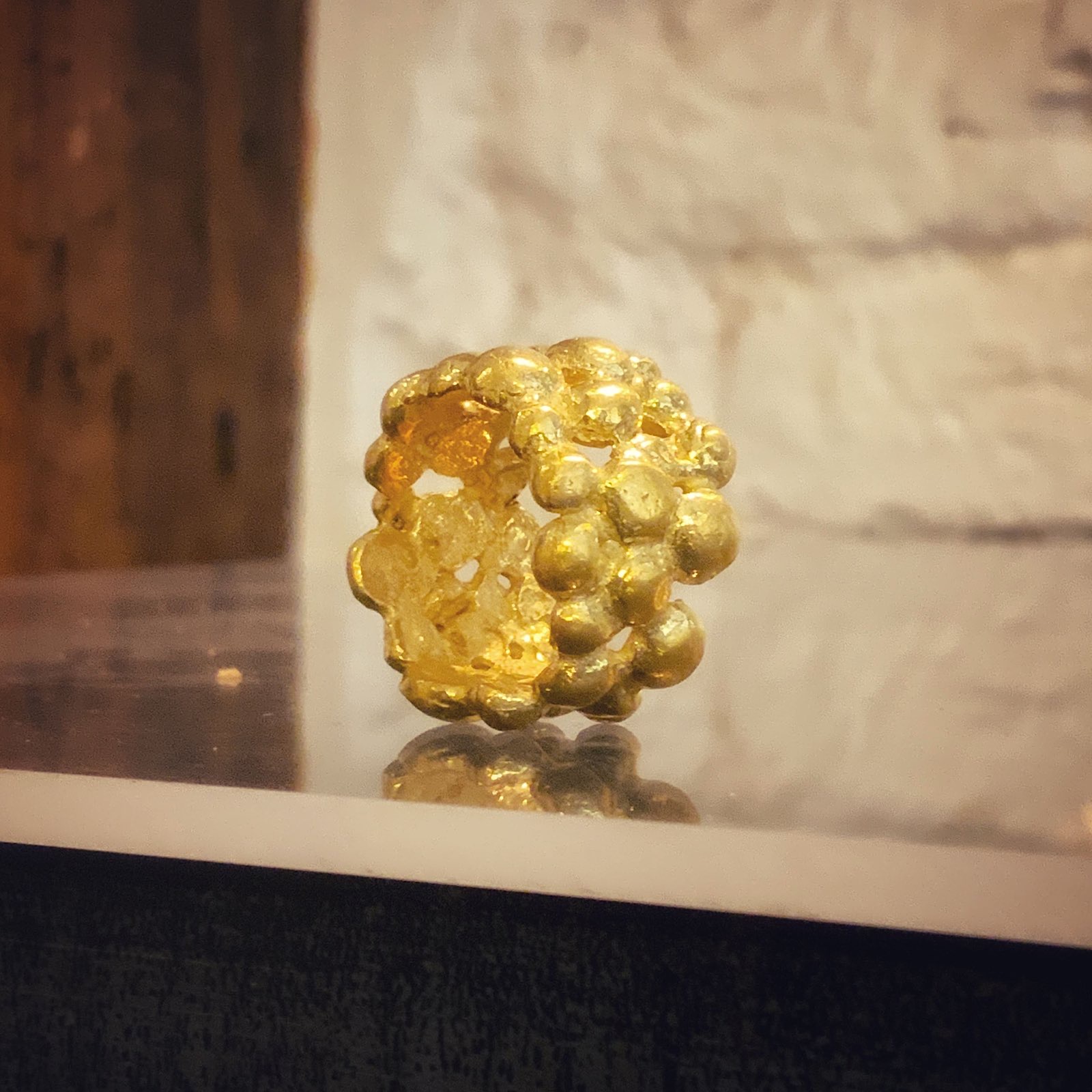 Anillo de oro formado por un racimo de bolitas