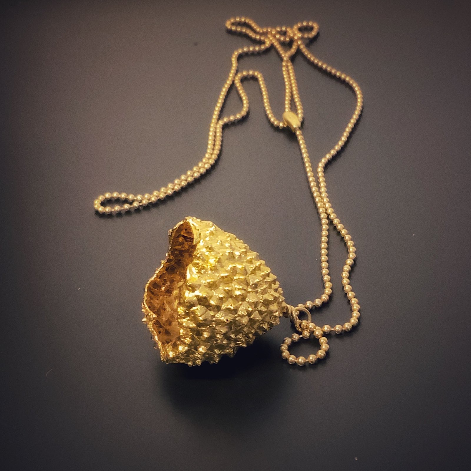 Colgante de oro con textura de roca y acabado martilleado