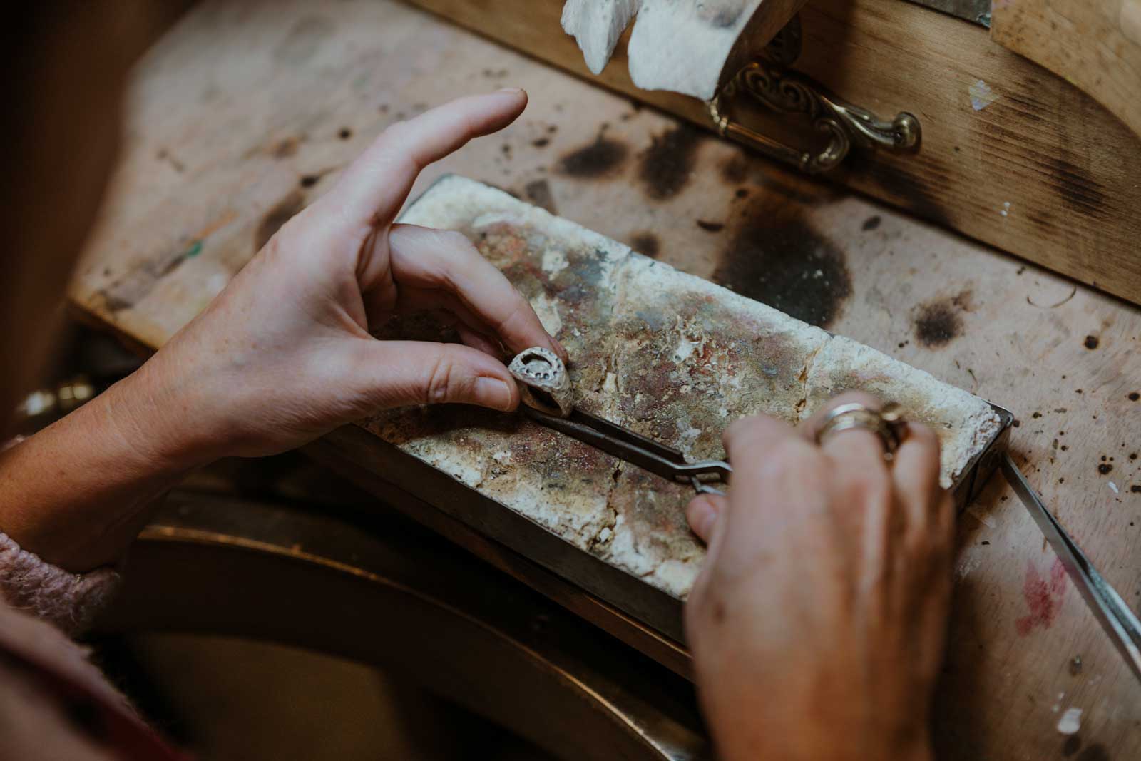 Detalle de manos trabajando una pieza con lima, en el taller de Ganboa